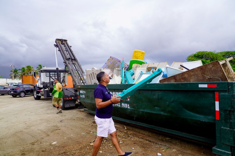 Volunteers participate in the final Baki den Bario cleanup event, filling waste containers at Marlboro Ballpark.