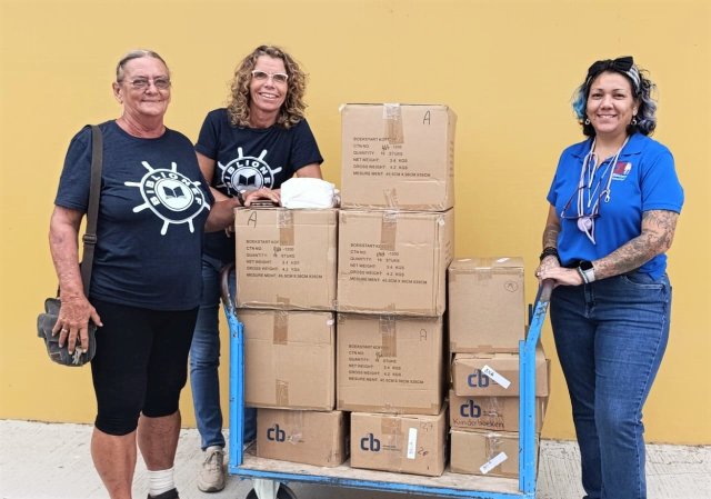 Biblionef team handing over children's books to Aruba youth library