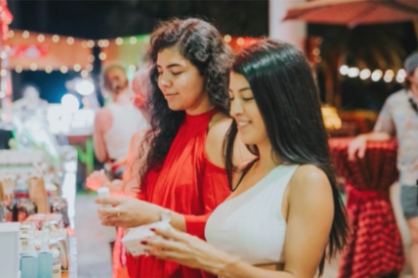 Visitors exploring handmade crafts at Hilton Aruba's holiday artisan market.