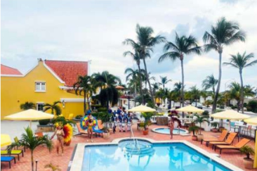 Guests enjoying Aruba Carnival celebrations at Amsterdam Manor Beach Resort with vibrant costumes and music
