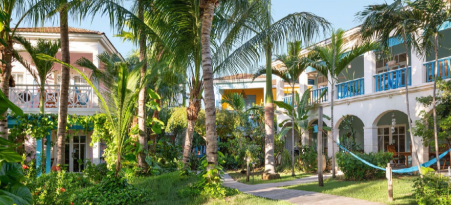 A serene view of Boardwalk Boutique Hotel’s casitas and lush tropical surroundings.