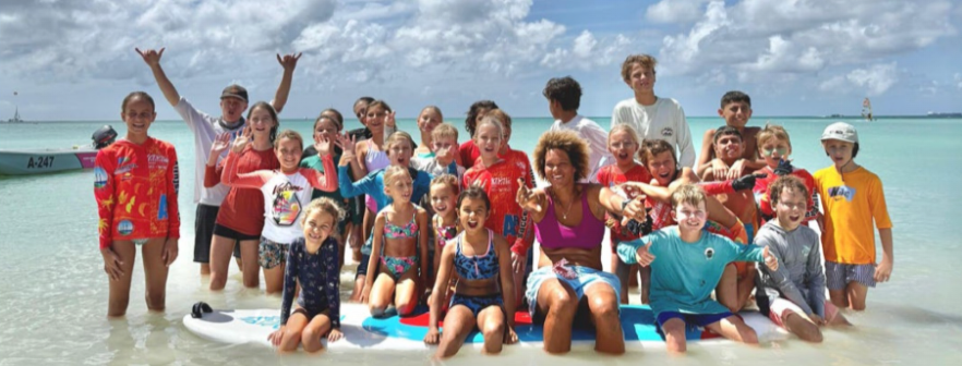 Kids participating in a windsurfing race at Fishermen’s Huts, hosted by Wind Racers Club Aruba.