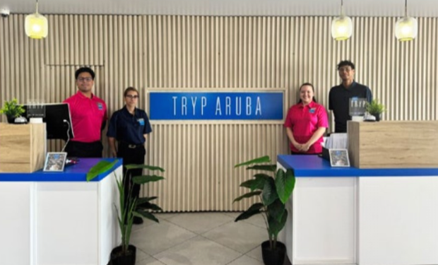 TRYP Aruba Brand Ambassador welcomes guests with champagne at check-in