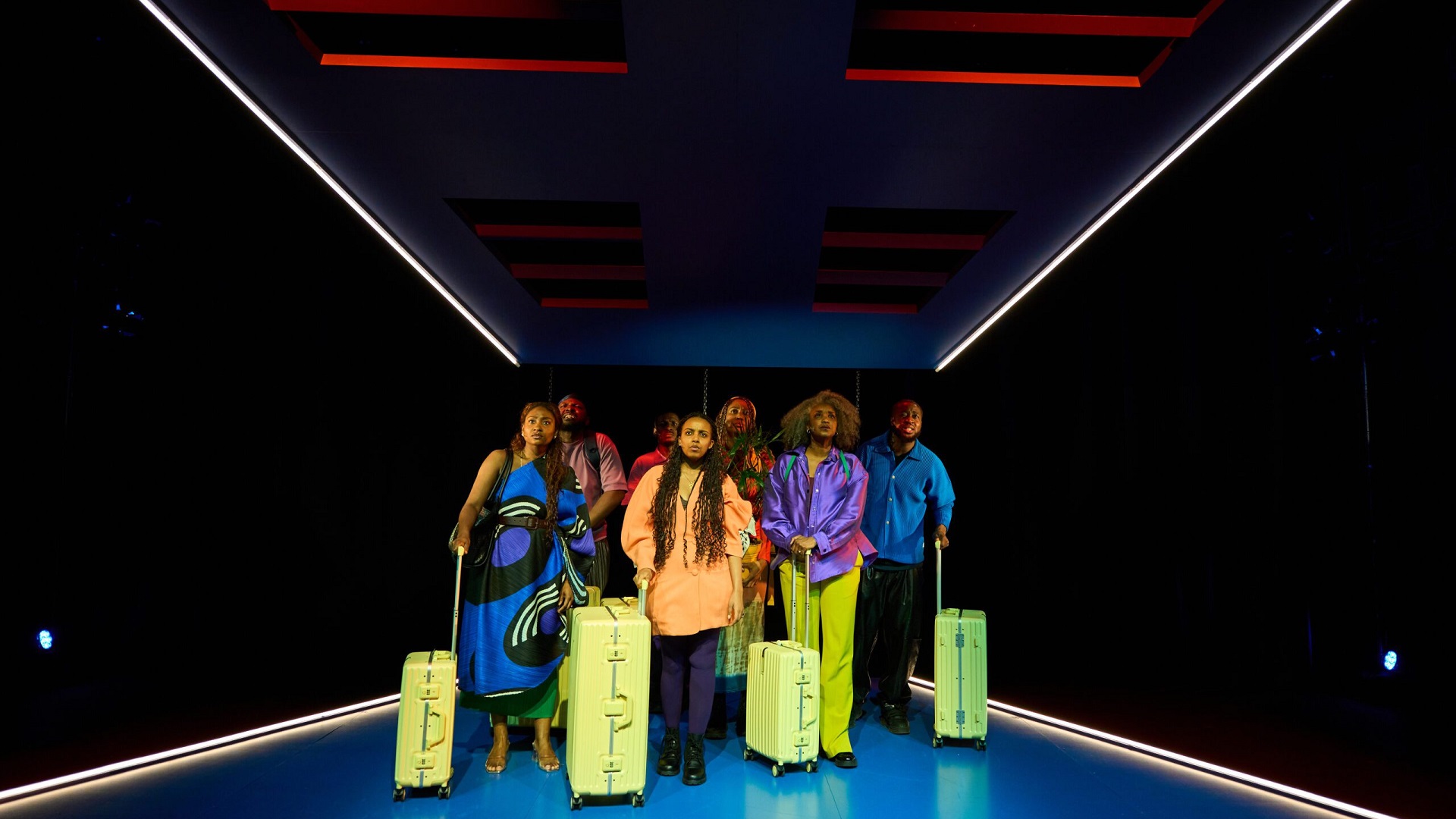 Cast walking with suitcases representing migration in KINGS Come Home Aruba
