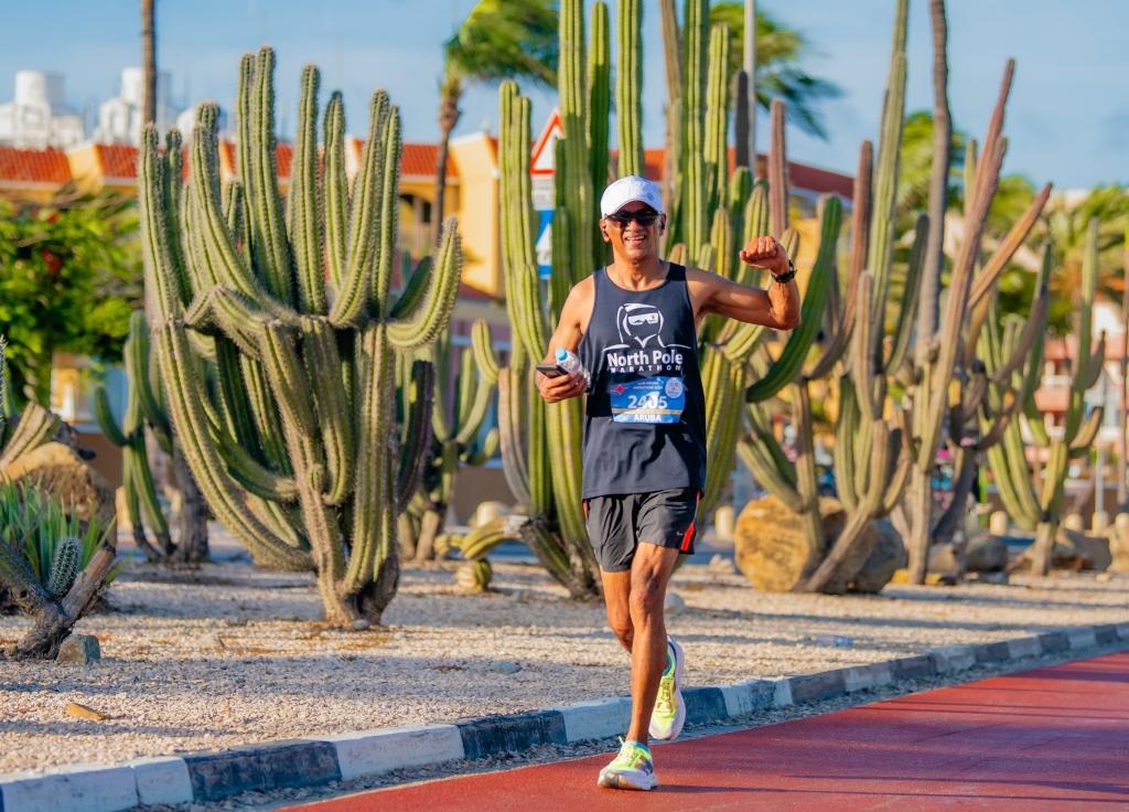 Runner participating in Aruba International Boulevard 10K race with scenic cactus surroundings