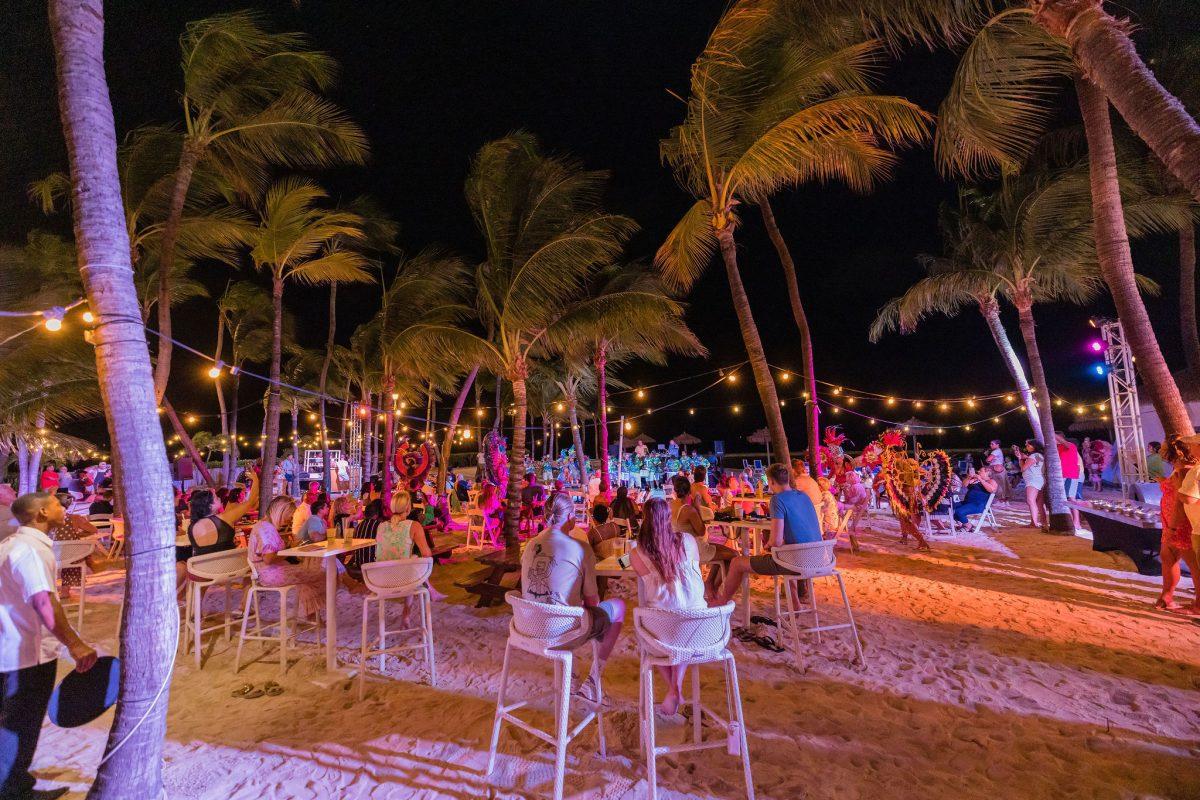 Lively nightlife scene at Palm Beach Aruba with bars, lights, and crowd